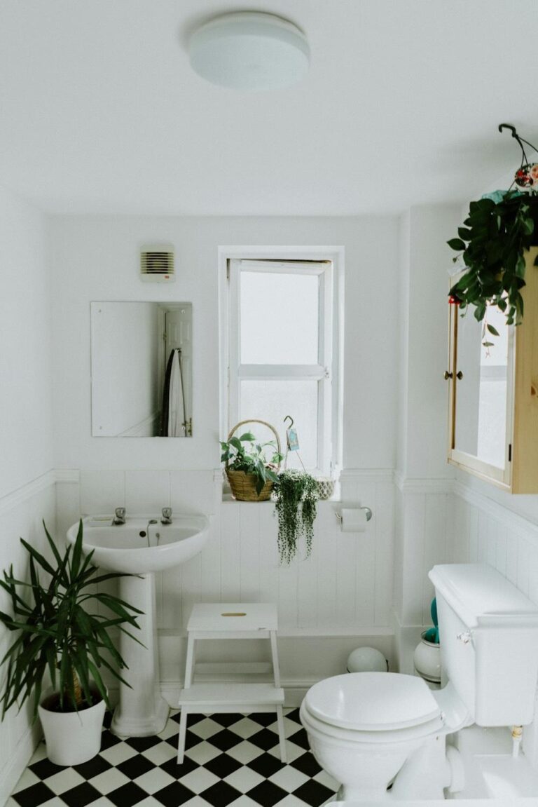 A luxury master bathroom demonstrating master bathroom remodeling tips with a freestanding white tub, dark green tiles, and a floating vanity. Premium architectural photography.